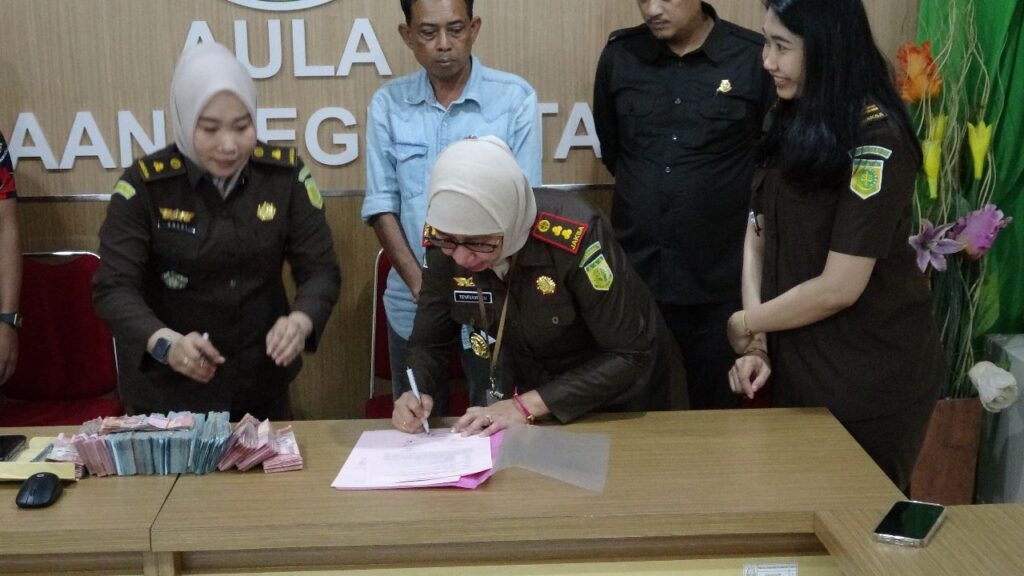 Kepala Kejaksaan Negeri Takalar Tenriawaru, S.H., M.H. menandatangani Berita Acara Penyerahan Pembayaran Pemulihan Keuangan Negara.